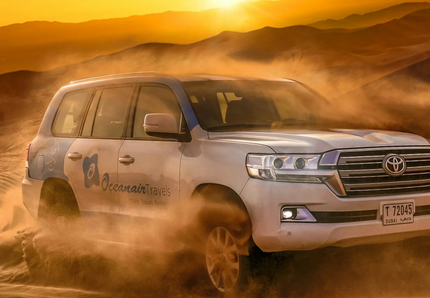 Four-wheel-drive vehicle crossing golden desert dunes