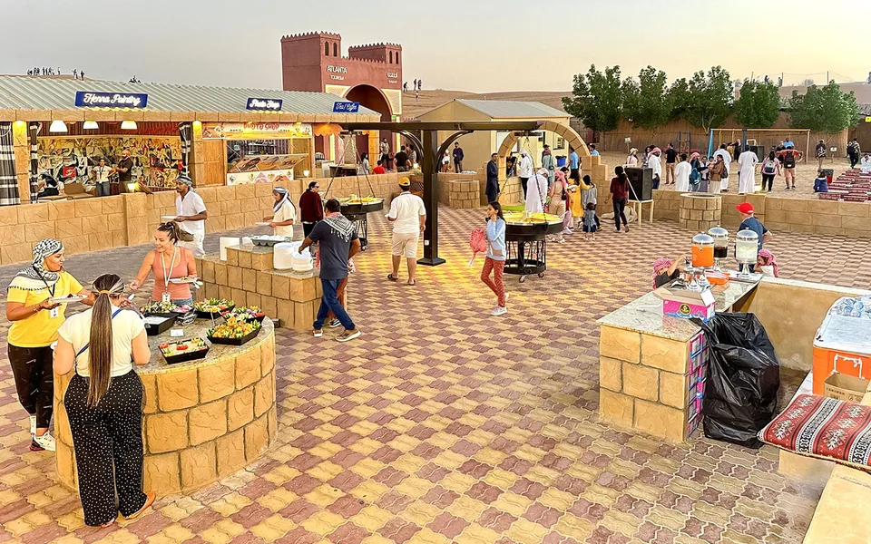 Guests choosing food at a desert camp buffet