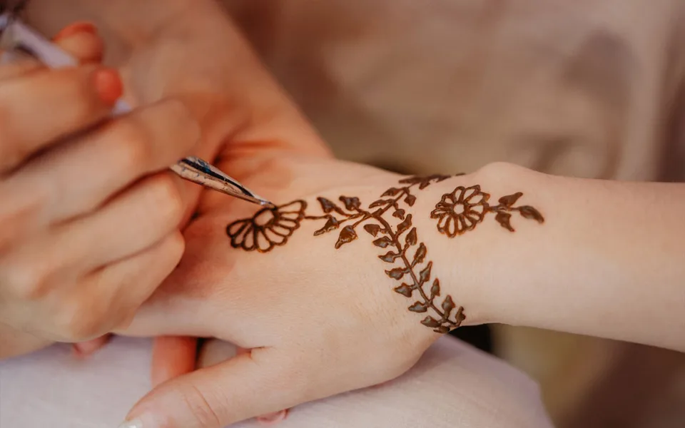 Henna being applied to a guest’s hand at a desert camp
