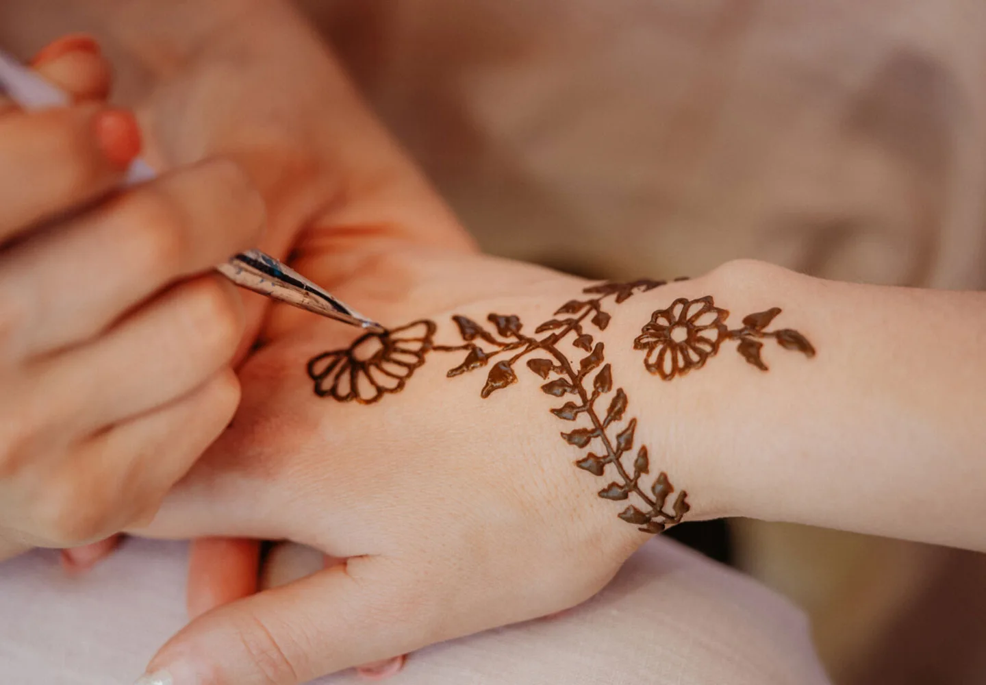 Henna being applied to a guest’s hand at a desert camp
