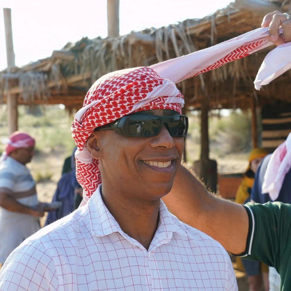 Desert safari guest wearing a headscarf and sunglasses
