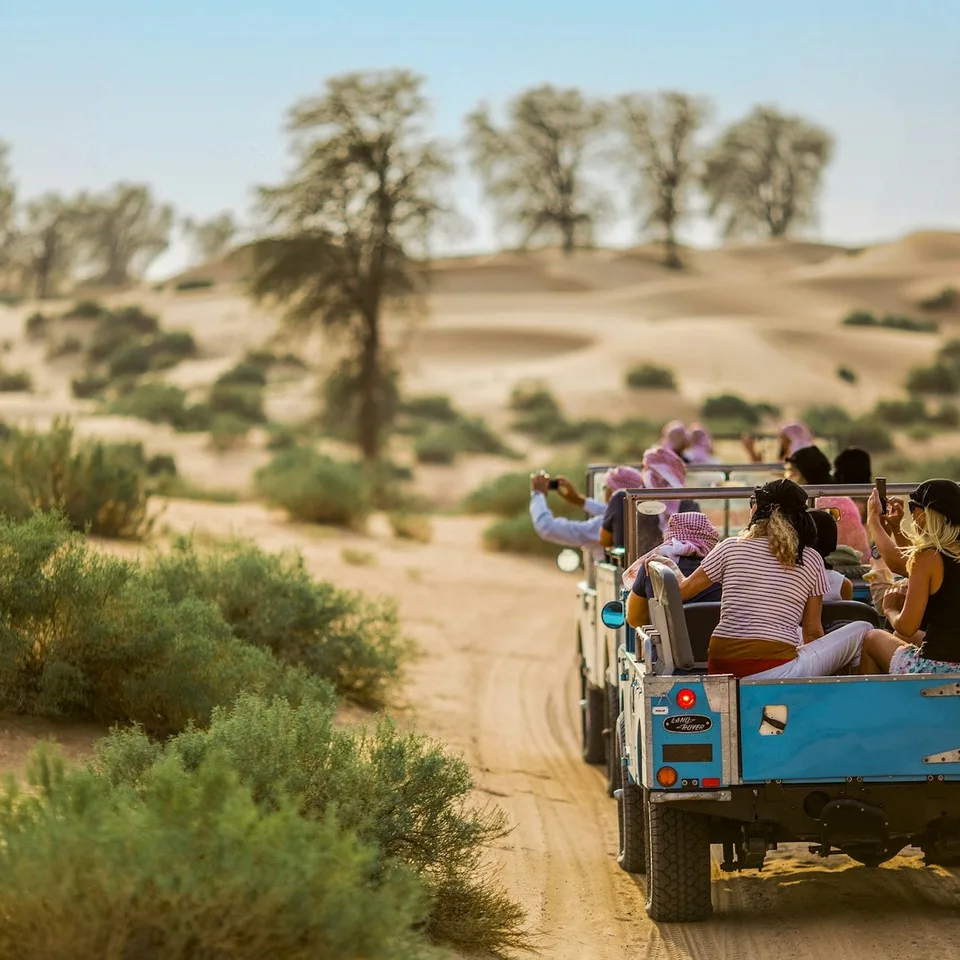 Guests travelling through the desert in vintage open vehicles