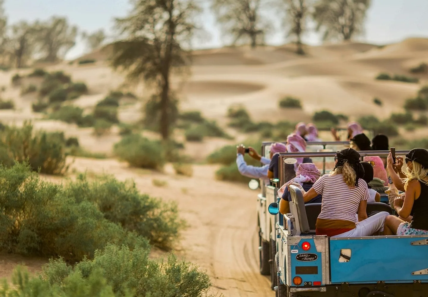 Guests travelling through the desert in vintage open vehicles