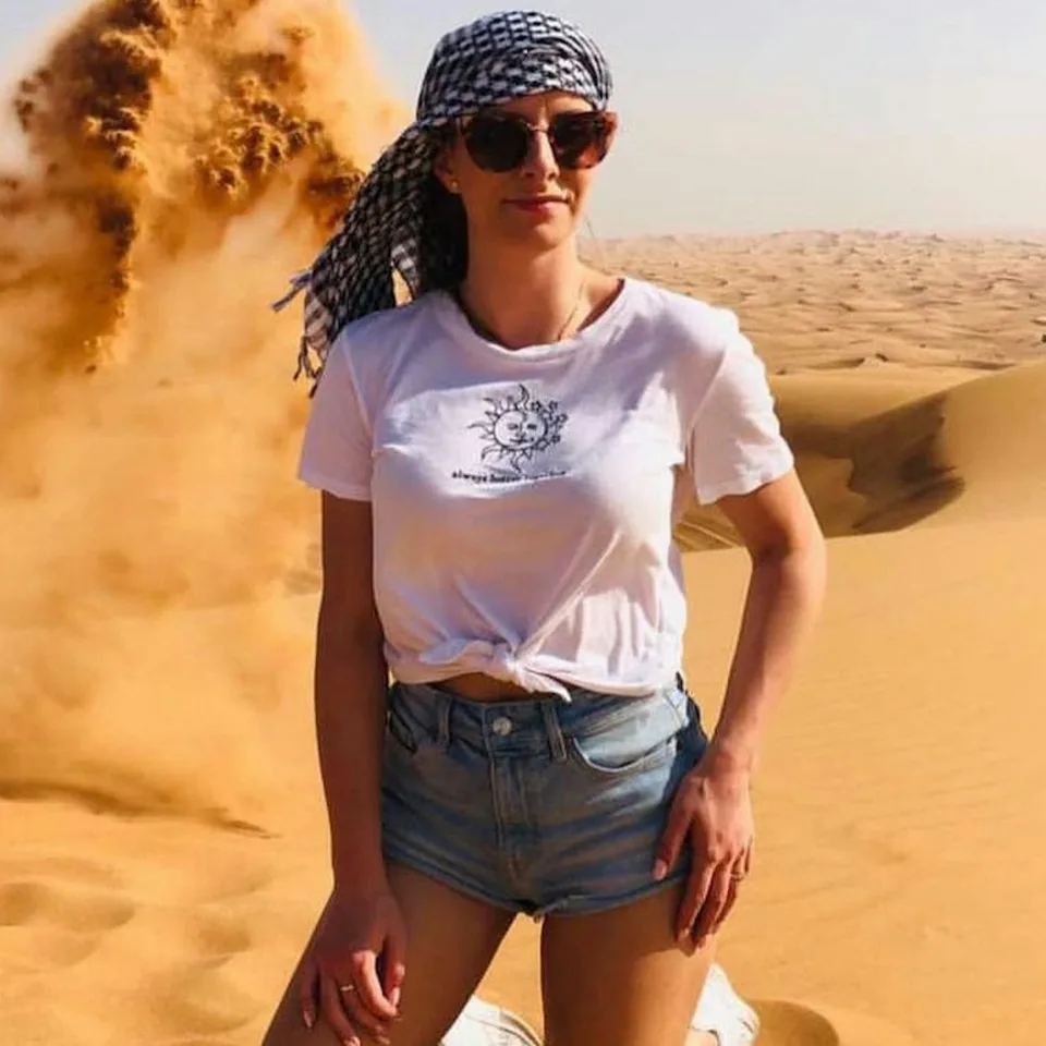 Guest trying sandboarding on a dune